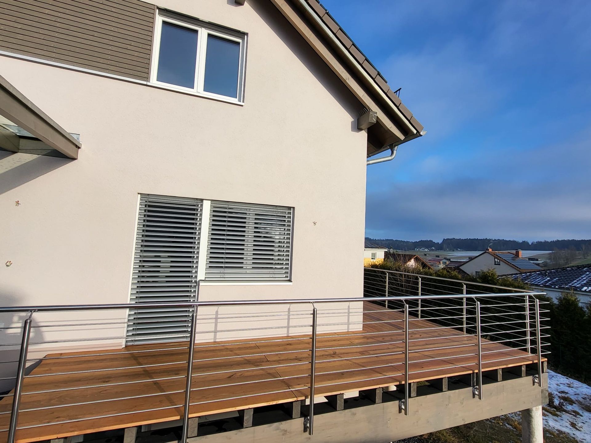 Balkonanbau mit Holzboden und Metallgeländer