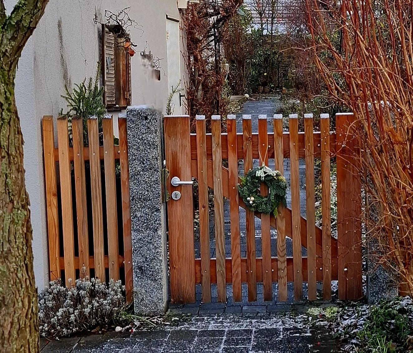 Bau eines Gartenzauns aus Holz und Granitsteinen