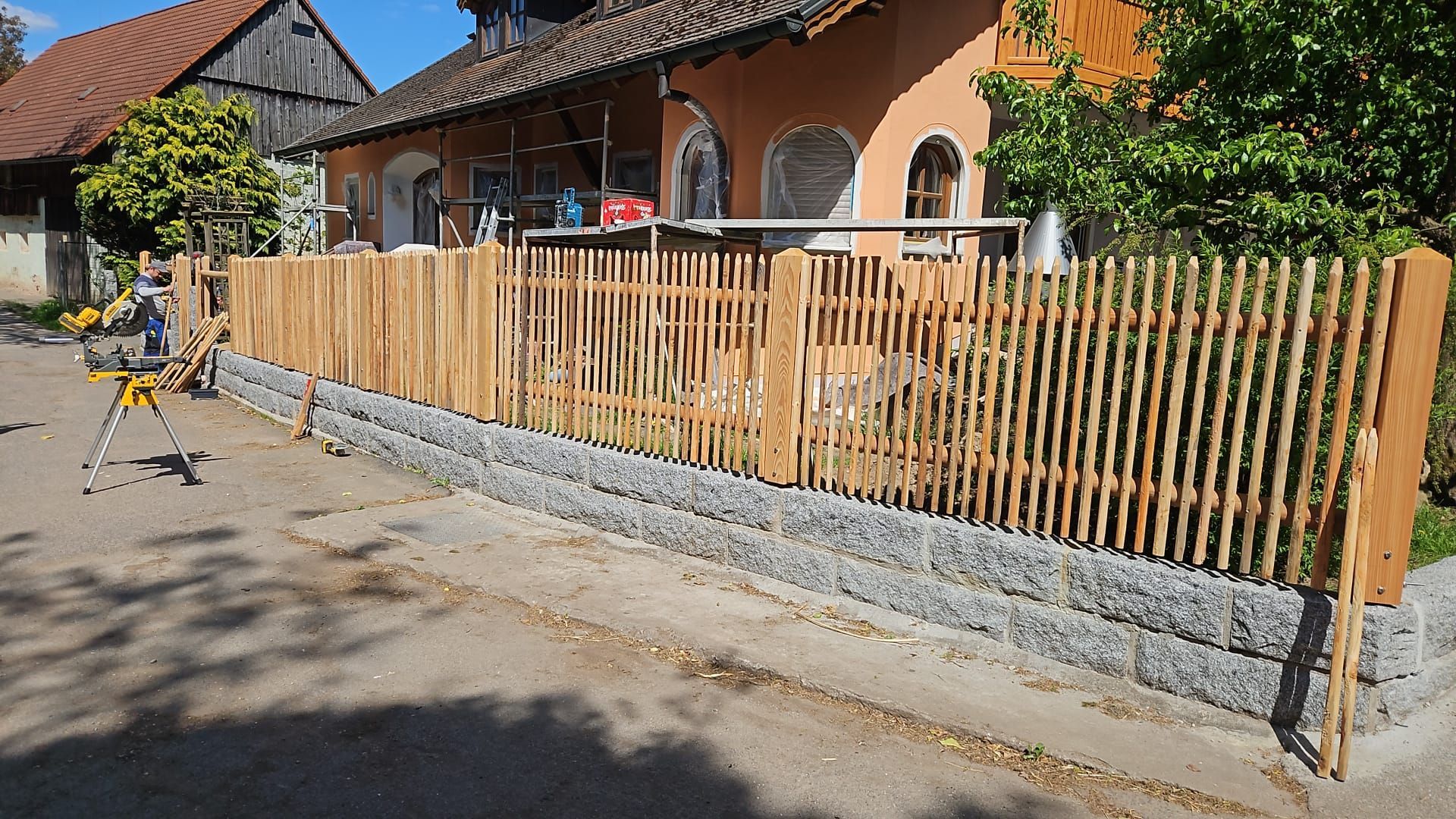 Gartenzaun aus Stein und Rundholz