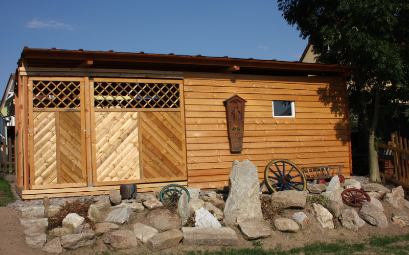 Holzverkleidung für eine Gartenhütte mit Steingarten