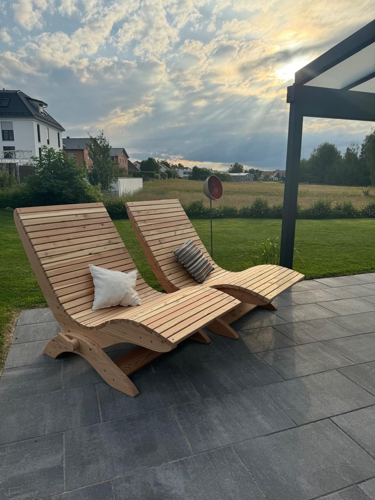 Geschwungene Liegestühle aus Holz auf einer Terrasse