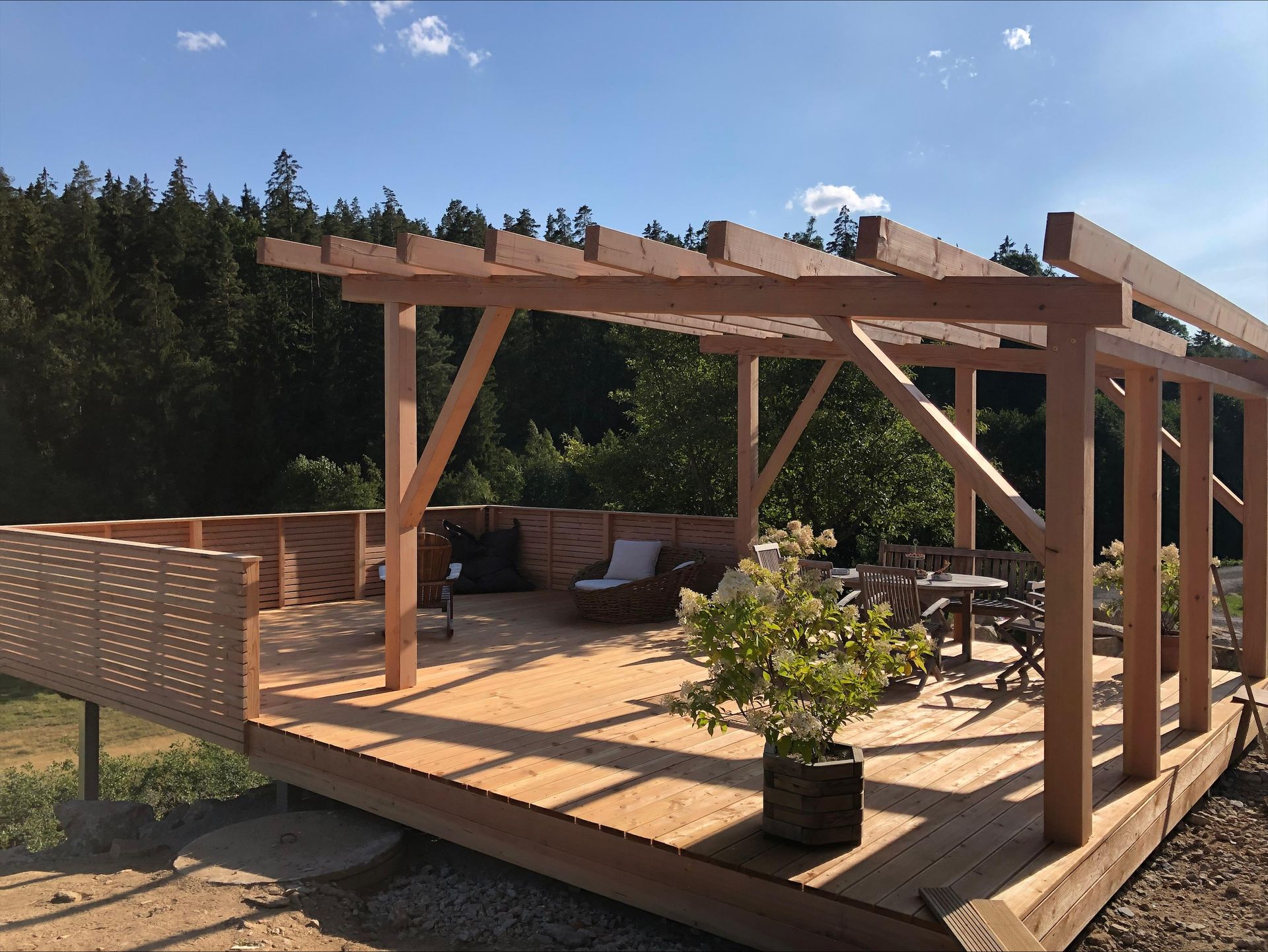 Erhöhte Holzterrasse mit Balkon und Geländer sowie Pergola