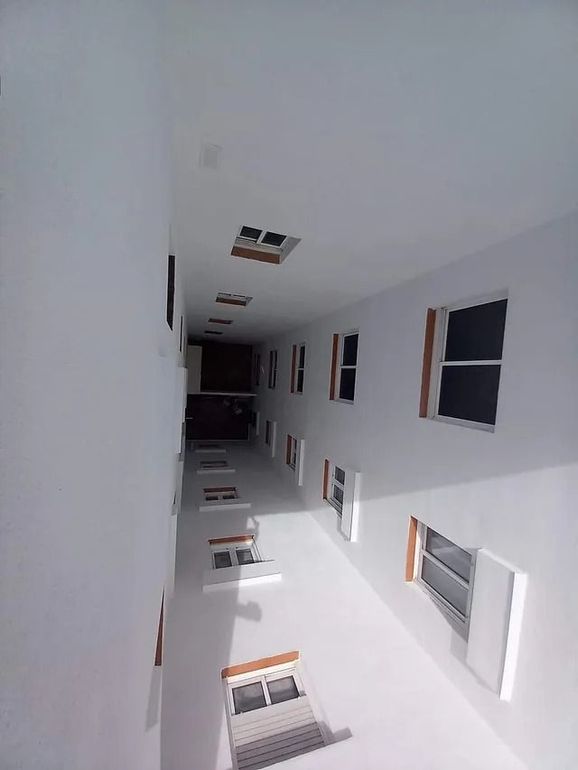 Mirando hacia arriba a un edificio con muchas ventanas.