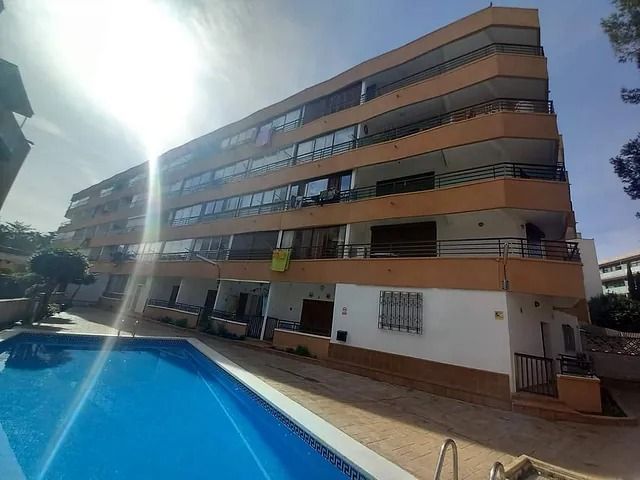 Un gran edificio de apartamentos con piscina enfrente.