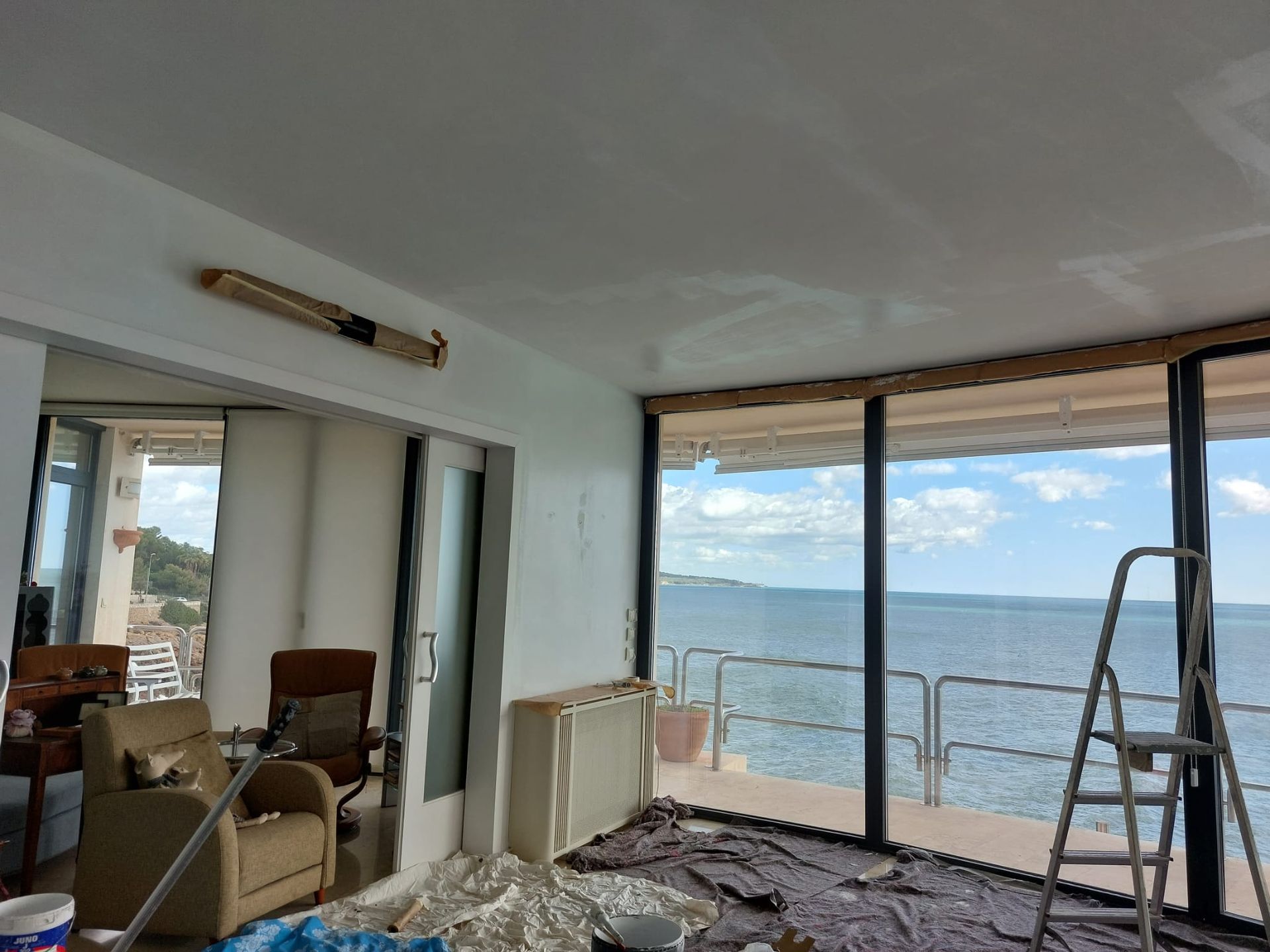 Una sala de estar con vista al mar y una escalera.
