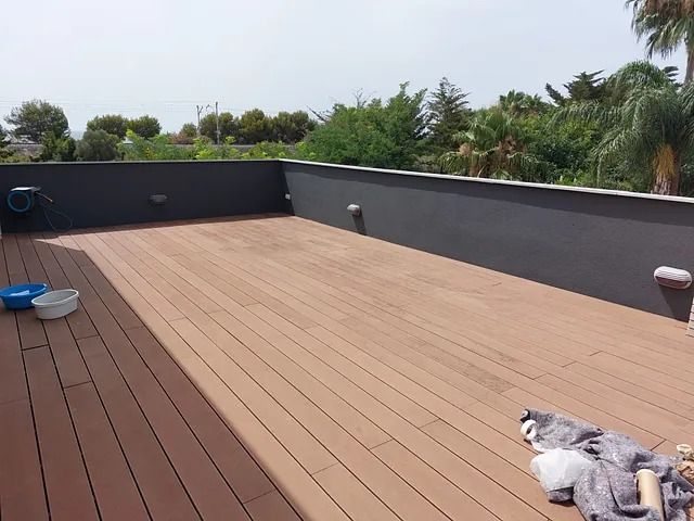 Un perro está acostado en una plataforma de madera con cuencos encima.