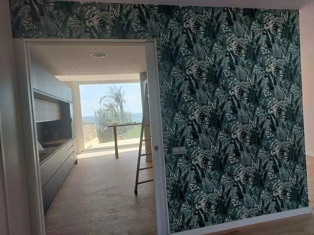 Una habitación con una escalera colgada en la pared y una ventana grande.