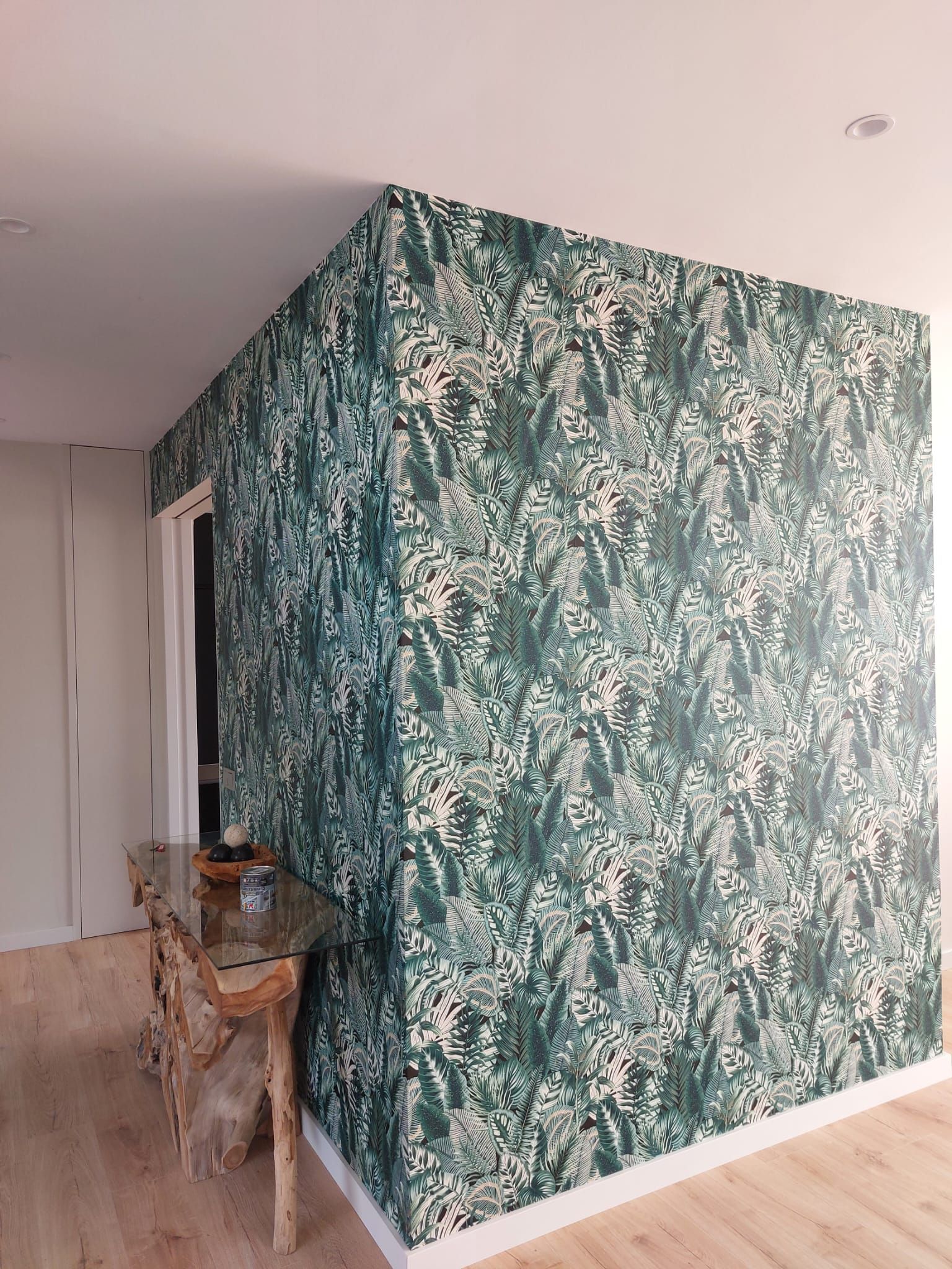 Una habitación con una pared verde y una mesa en la esquina.