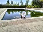 Un hombre en cuclillas en el borde de una piscina