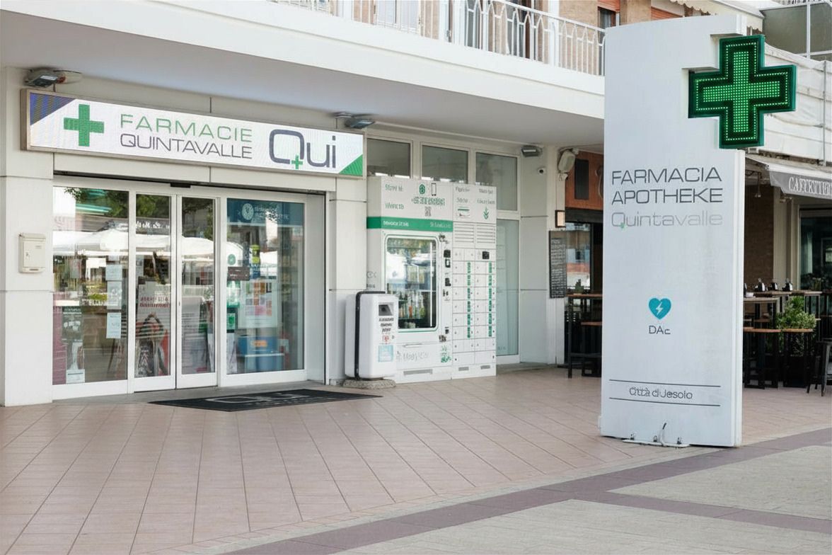 Negozio di farmacia con insegna a croce verde e ingresso in vetro all'interno di un centro commerciale.