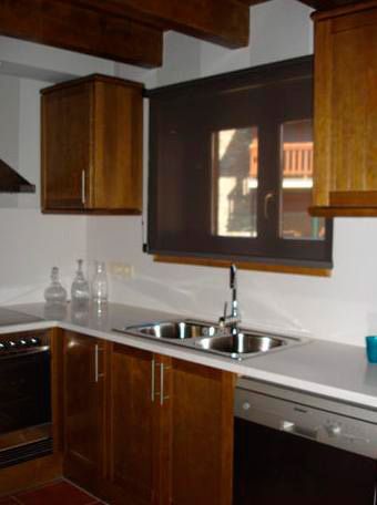 Una cocina con dos fregaderos y una ventana.