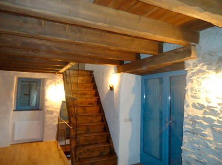 Una escalera de madera en una habitación con una puerta azul.