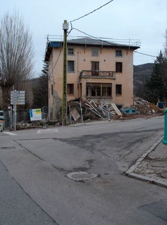 Un gran edificio está siendo demolido en medio de una calle.