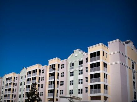 Un gran edificio de apartamentos con un cielo azul al fondo.