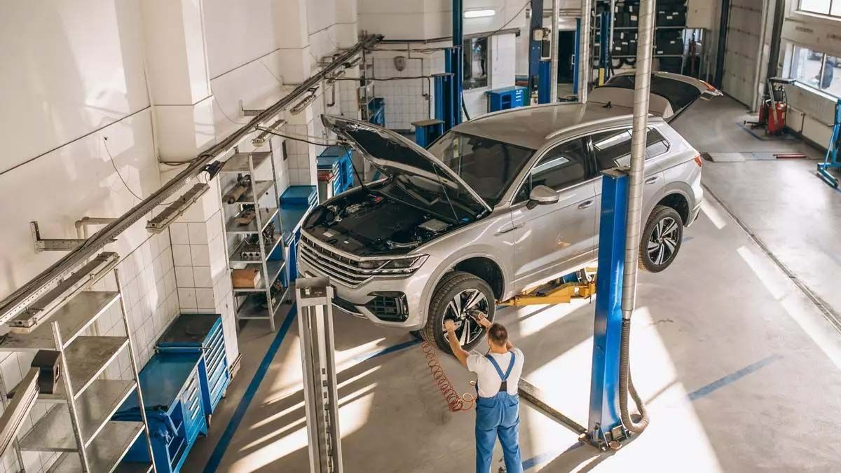 Un hombre está trabajando en un coche en un garaje.