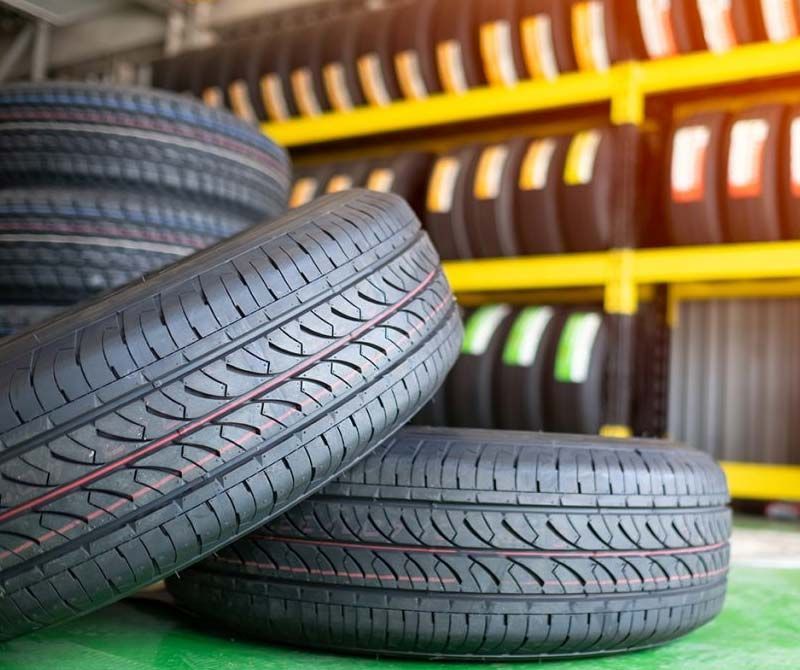 Una pila de neumáticos colocados uno encima del otro en una tienda de neumáticos.