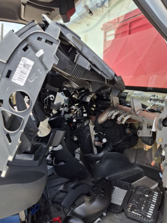 Tableau de bord d'un véhicule démonté pour acceder au système de climatisation.