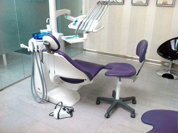 Un sillón dental morado y blanco en un consultorio dental.
