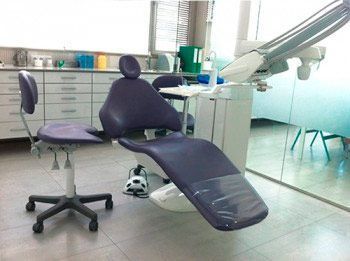 Un sillón dental morado en un consultorio dental.
