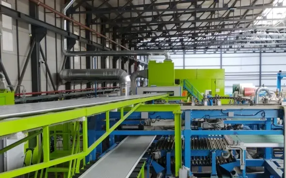 El interior de un almacén industrial se caracteriza por la presencia de maquinaria de gran tamaño de color verde lima.