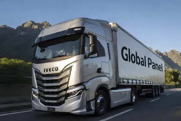 Un camión semirremolque Iveco plateado con un remolque