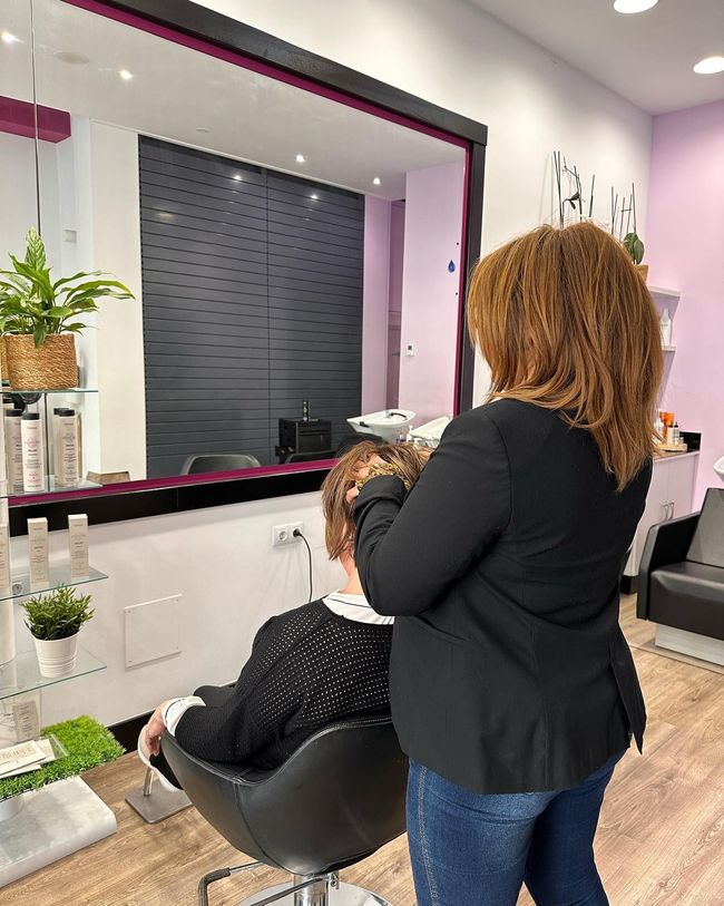 Una mujer se está cortando el pelo en una peluquería.