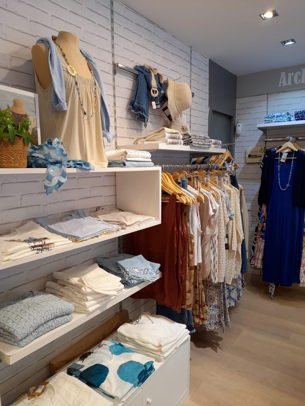 Una tienda llena de ropa y un maniquí.