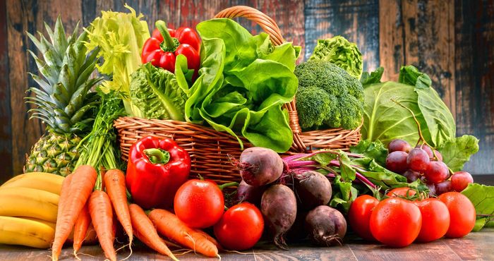 Surtido de frutas y verduras frescas, que incluyen piña, plátanos, zanahorias, pimientos rojos, tomates, remolachas y otros
