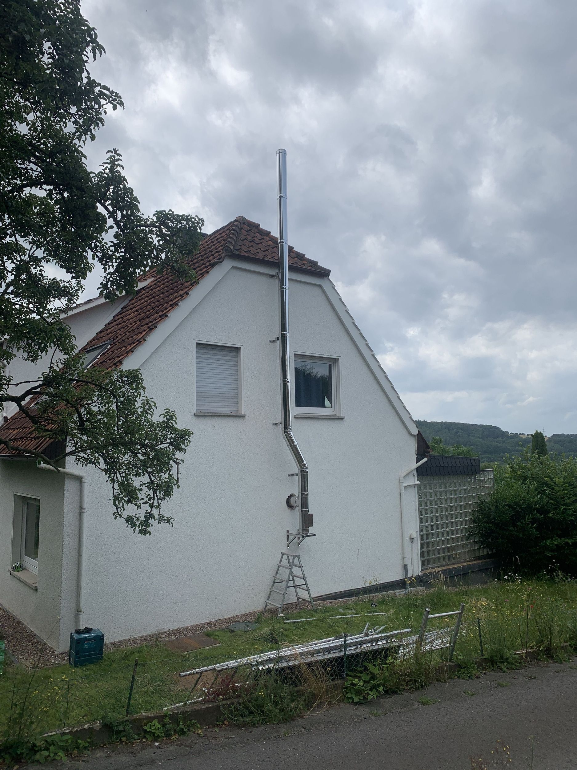 Ein weißes Haus mit einem Schornstein an der Seite