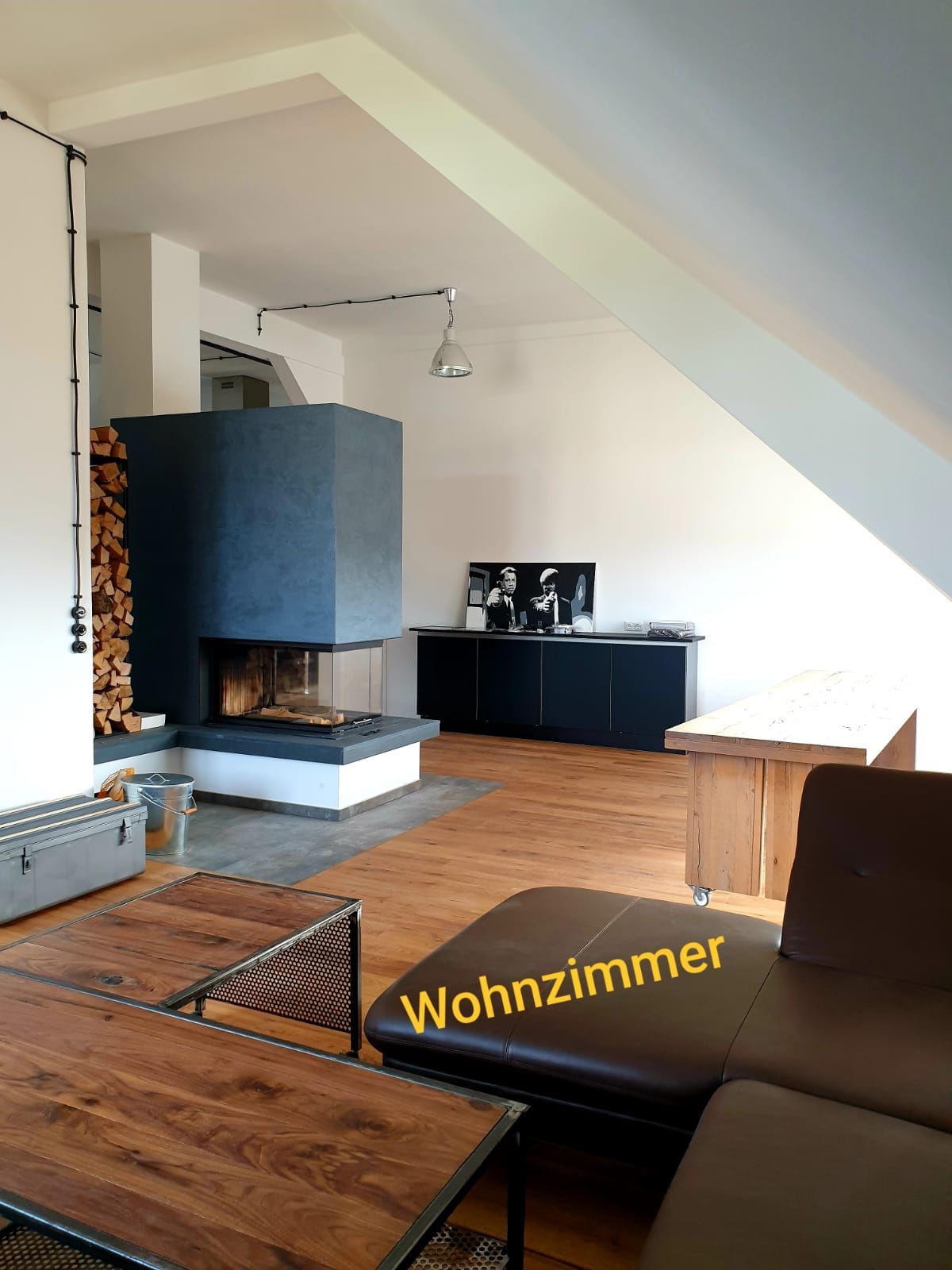 Ein Wohnzimmer mit Couch, Tisch und Kamin.