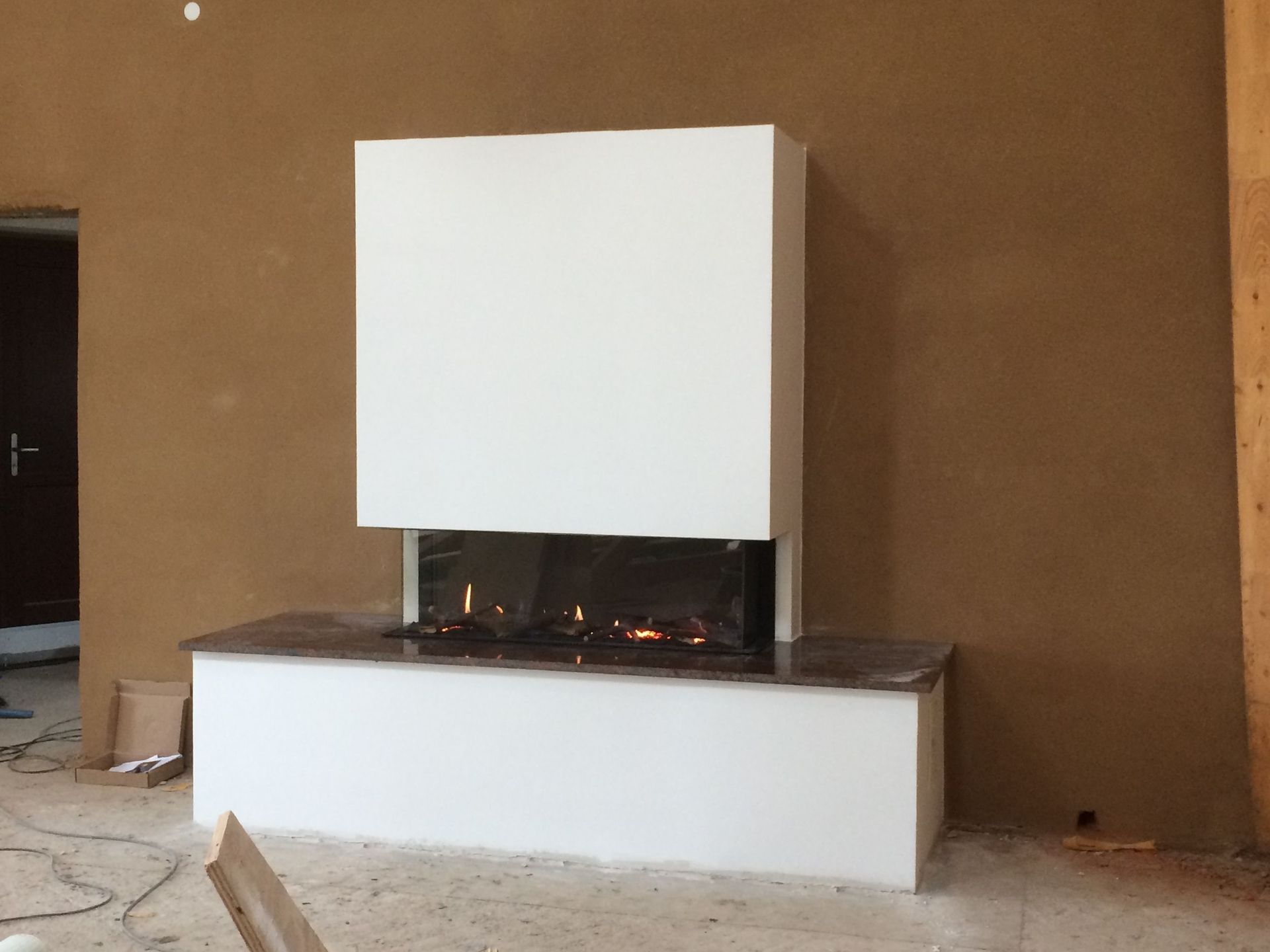 Ein Kamin in einem Raum mit einer braunen Wand