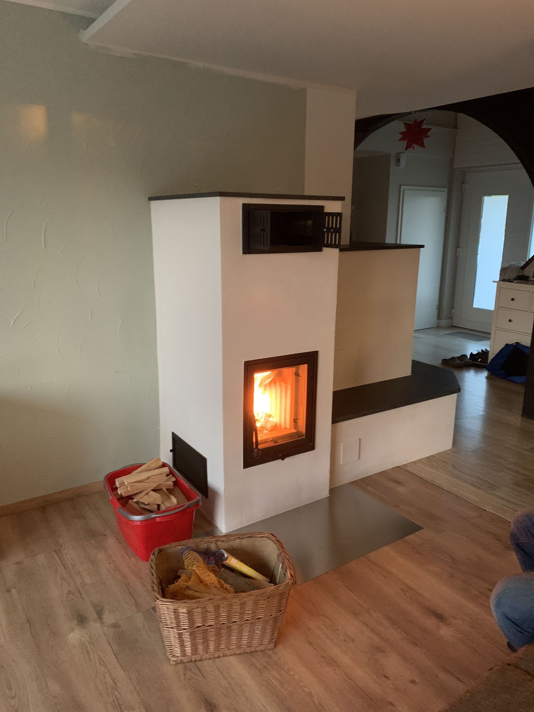 Ein Wohnzimmer mit Kamin und einem Korb Holz