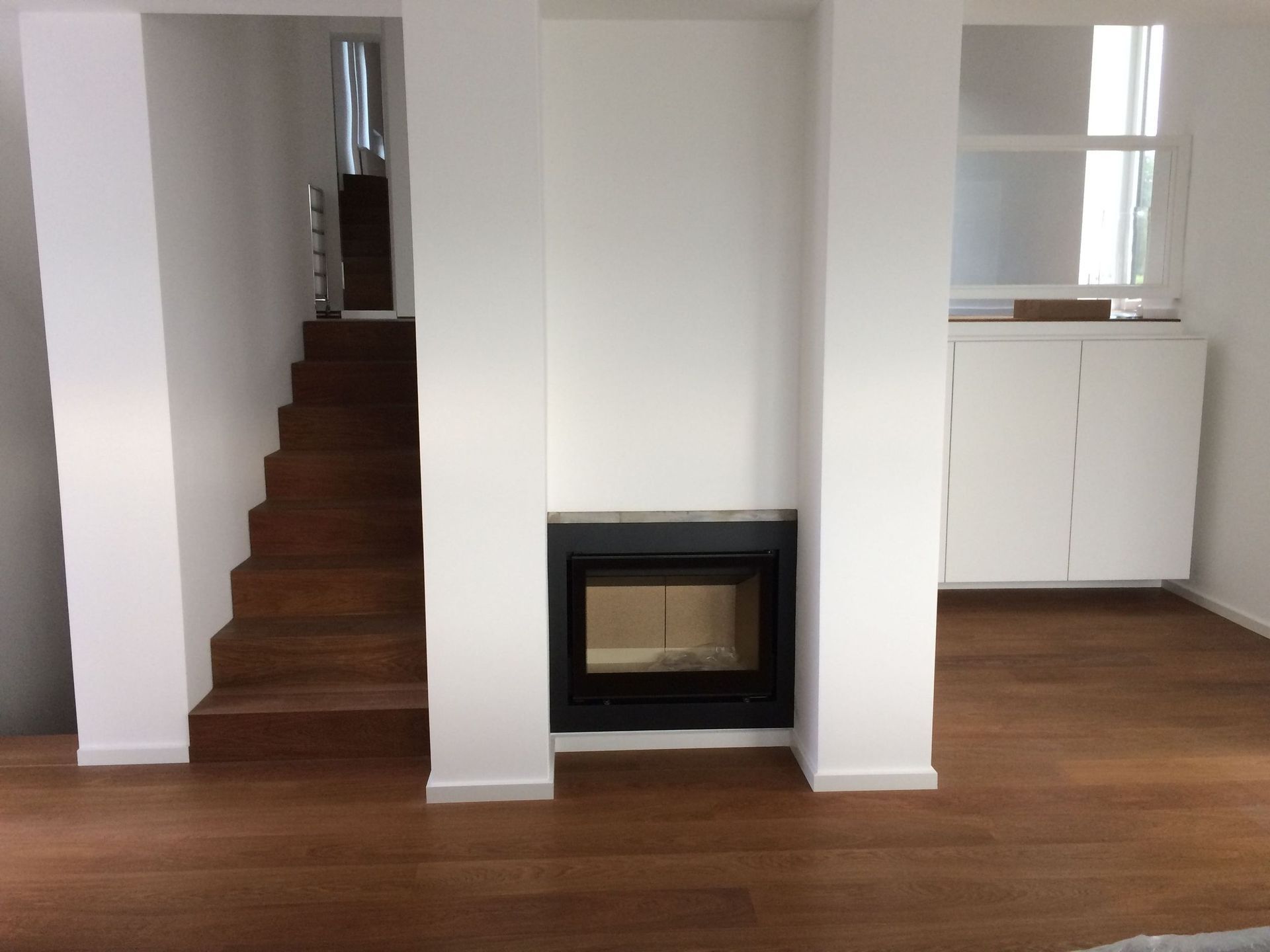 Ein Wohnzimmer mit Kamin und Treppe im Hintergrund