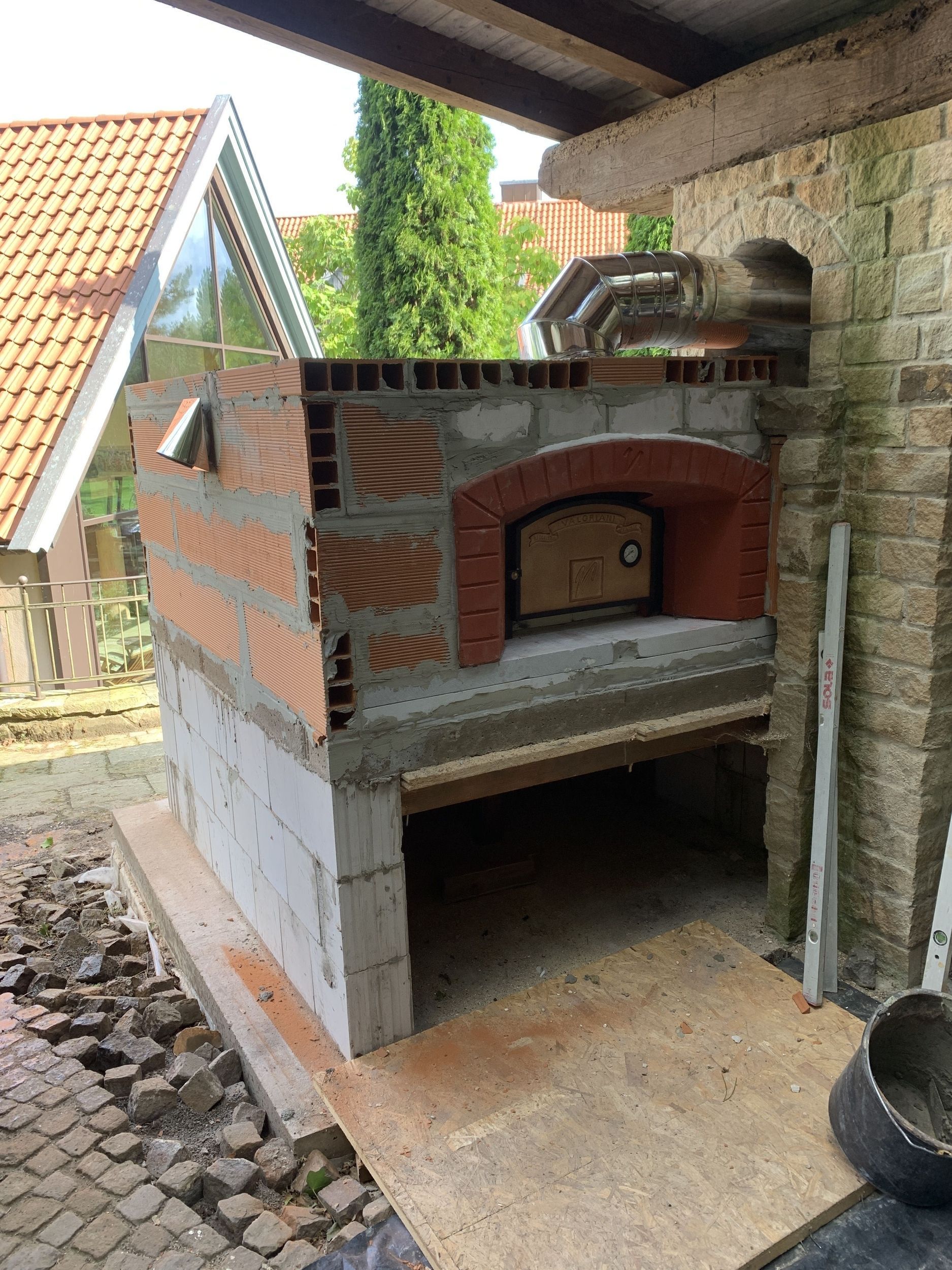 Im Hinterhof eines Hauses wird ein Steinofen gebaut.