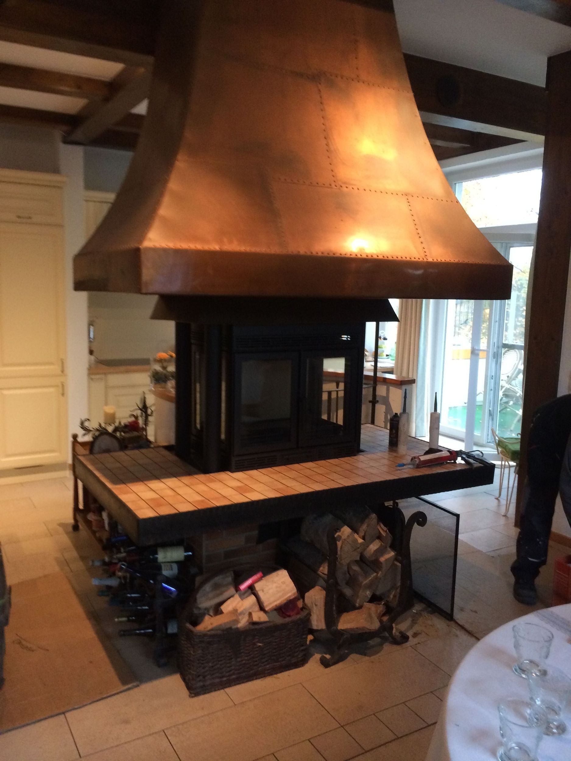 Ein Kamin mit einer Kupferhaube in einem Wohnzimmer