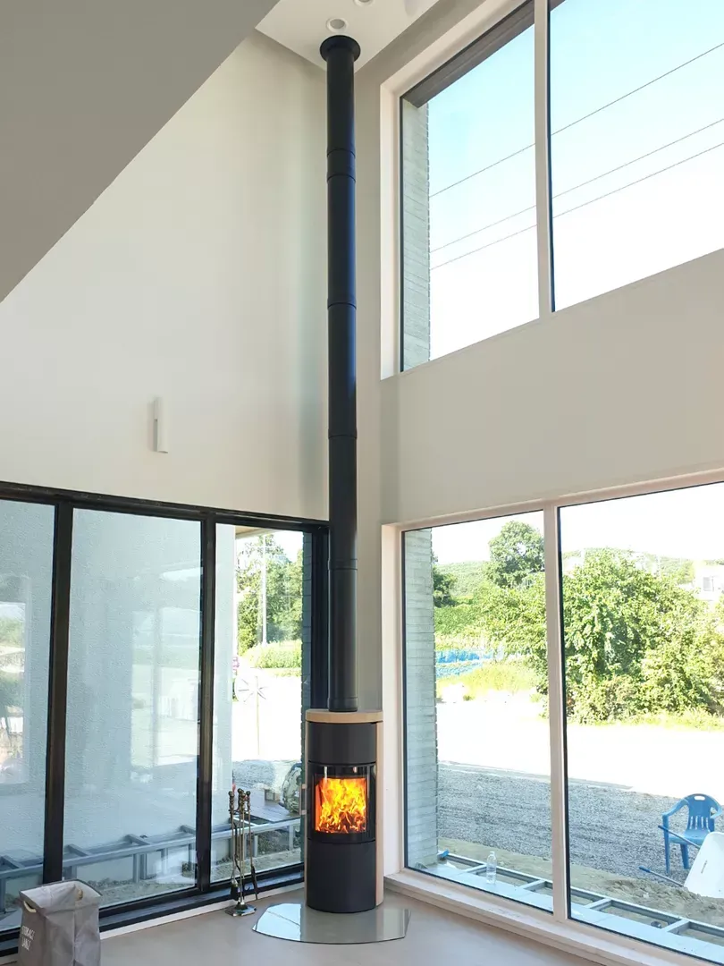 Ein Raum mit Kamin und vielen Fenstern