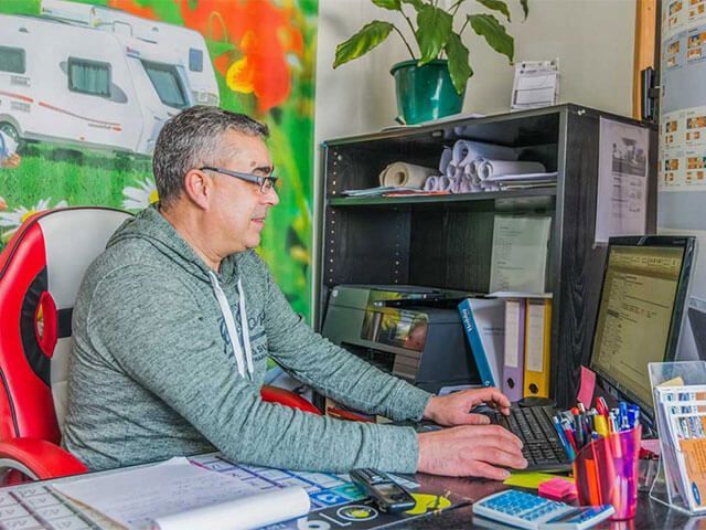 patron de ACL en train de travailler sur on ordinateur