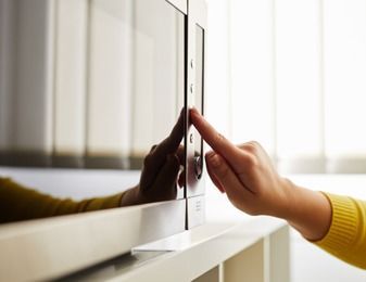 Una persona está presionando un botón en un horno microondas.