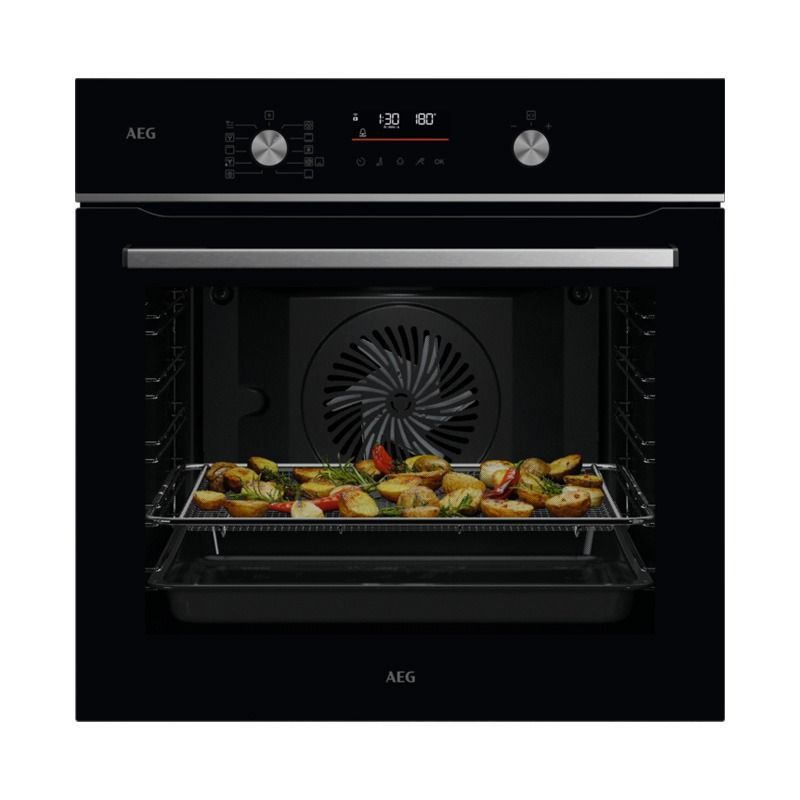 Un horno negro con patatas y verduras dentro.