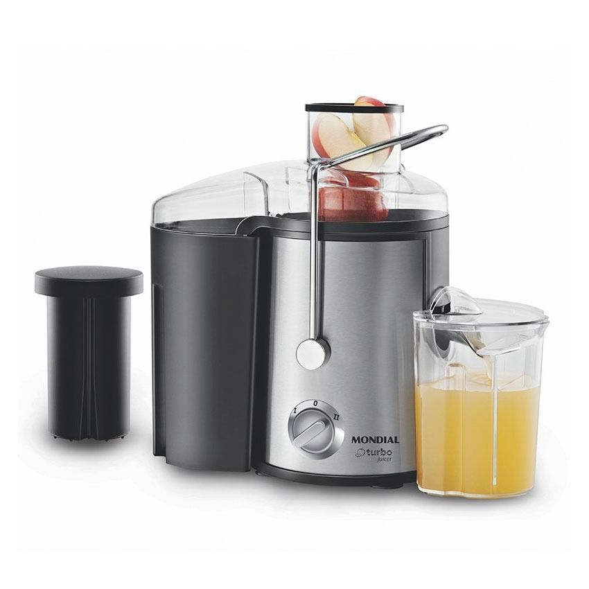 Un exprimidor de acero inoxidable con un vaso de jugo de naranja al lado.