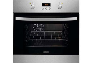 Un horno de acero inoxidable con una puerta negra está sentado sobre una superficie blanca.
