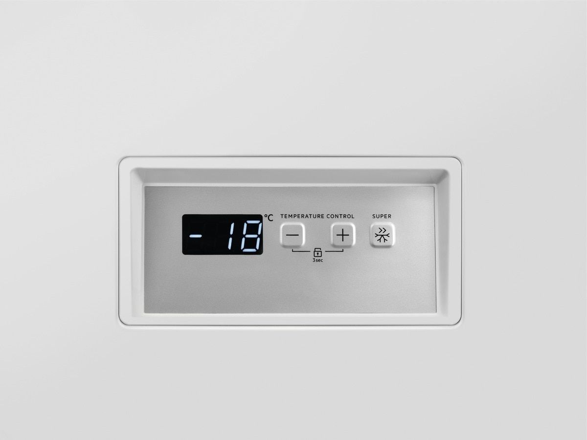 Un congelador horizontal blanco con la puerta abierta sobre un fondo blanco.