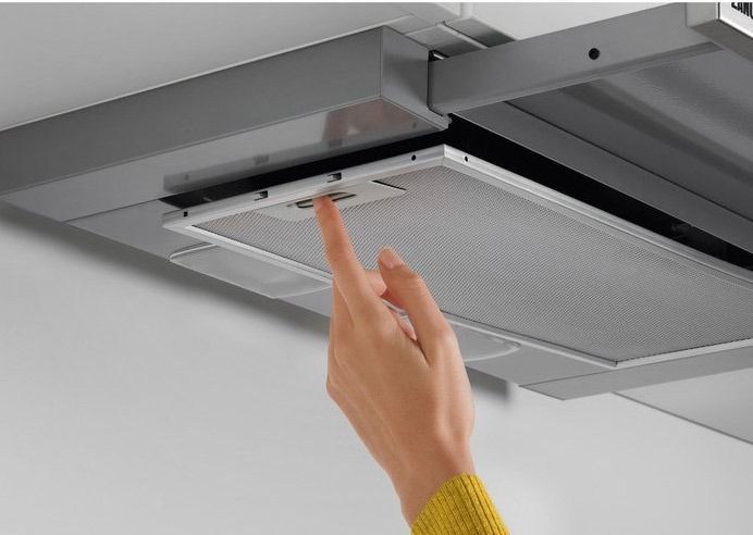 Una campana de acero inoxidable cuelga del techo de una cocina.