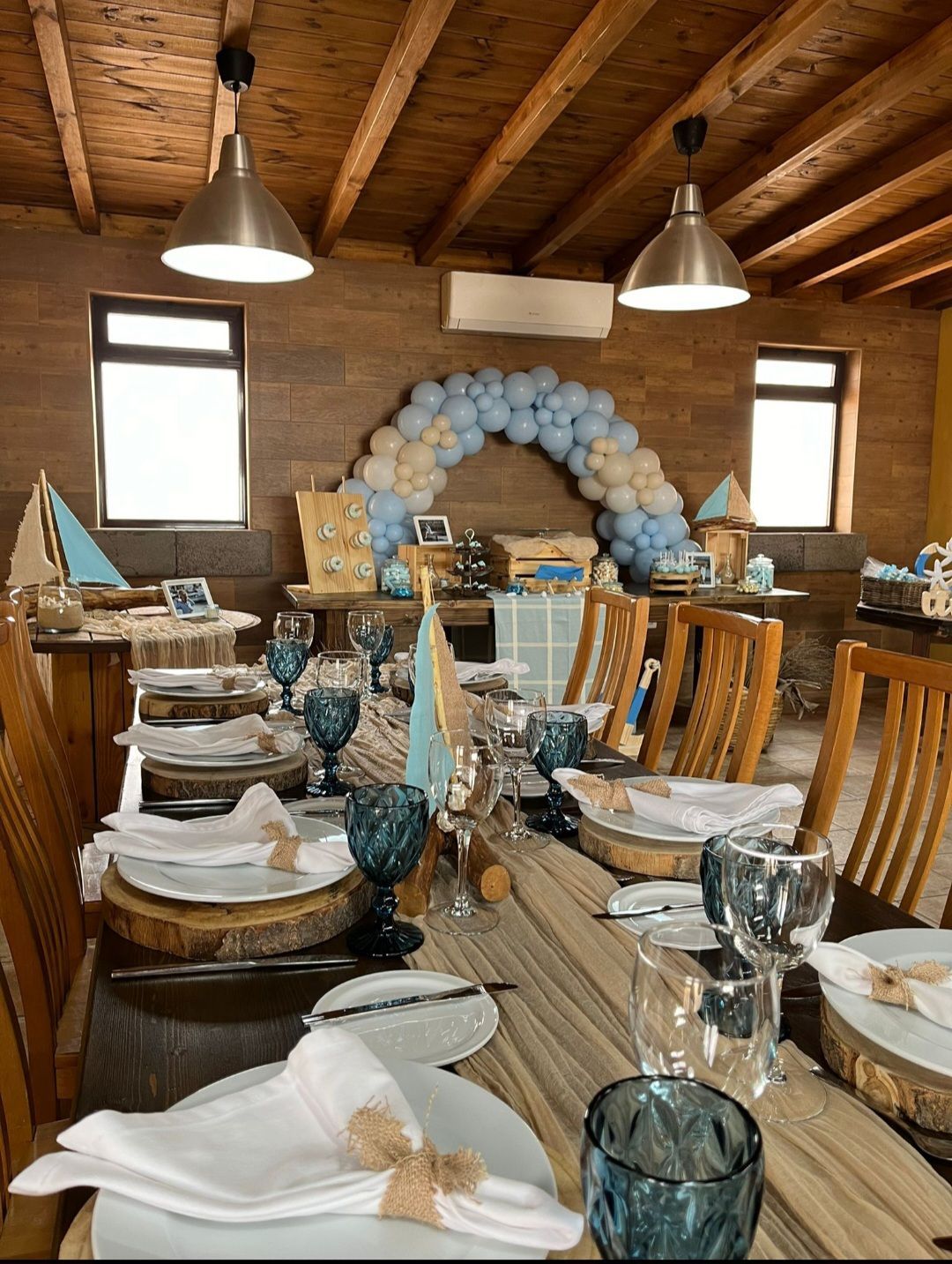 Una mesa preparada para un baby shower con platos, vasos, servilletas y globos.