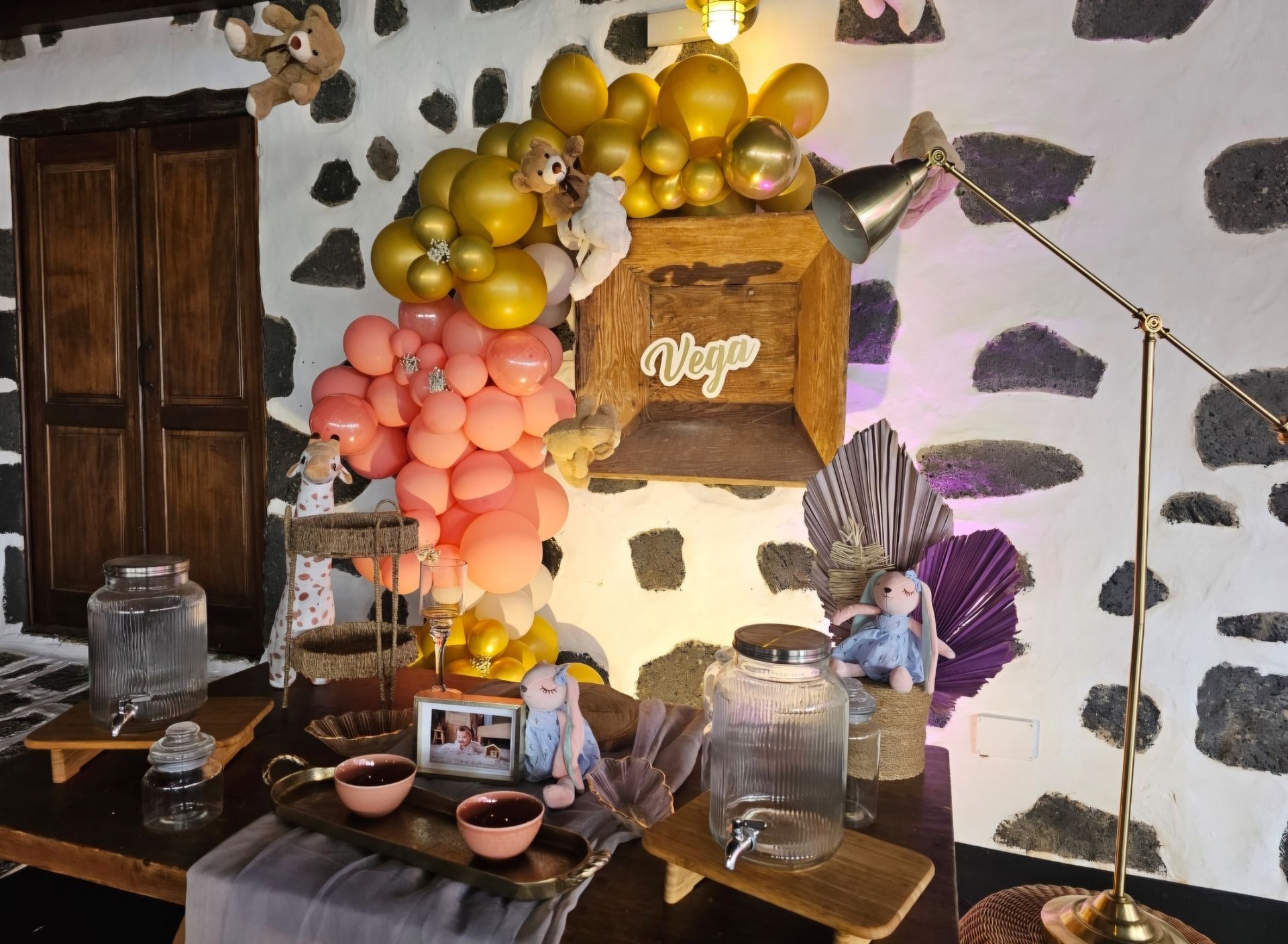 Una habitación con una mesa y globos encima.