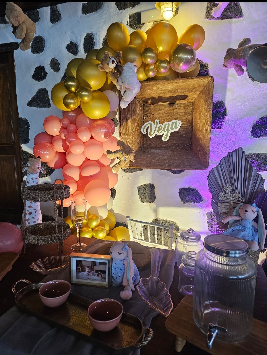 Una habitación decorada con globos, un marco de fotos y un frasco.
