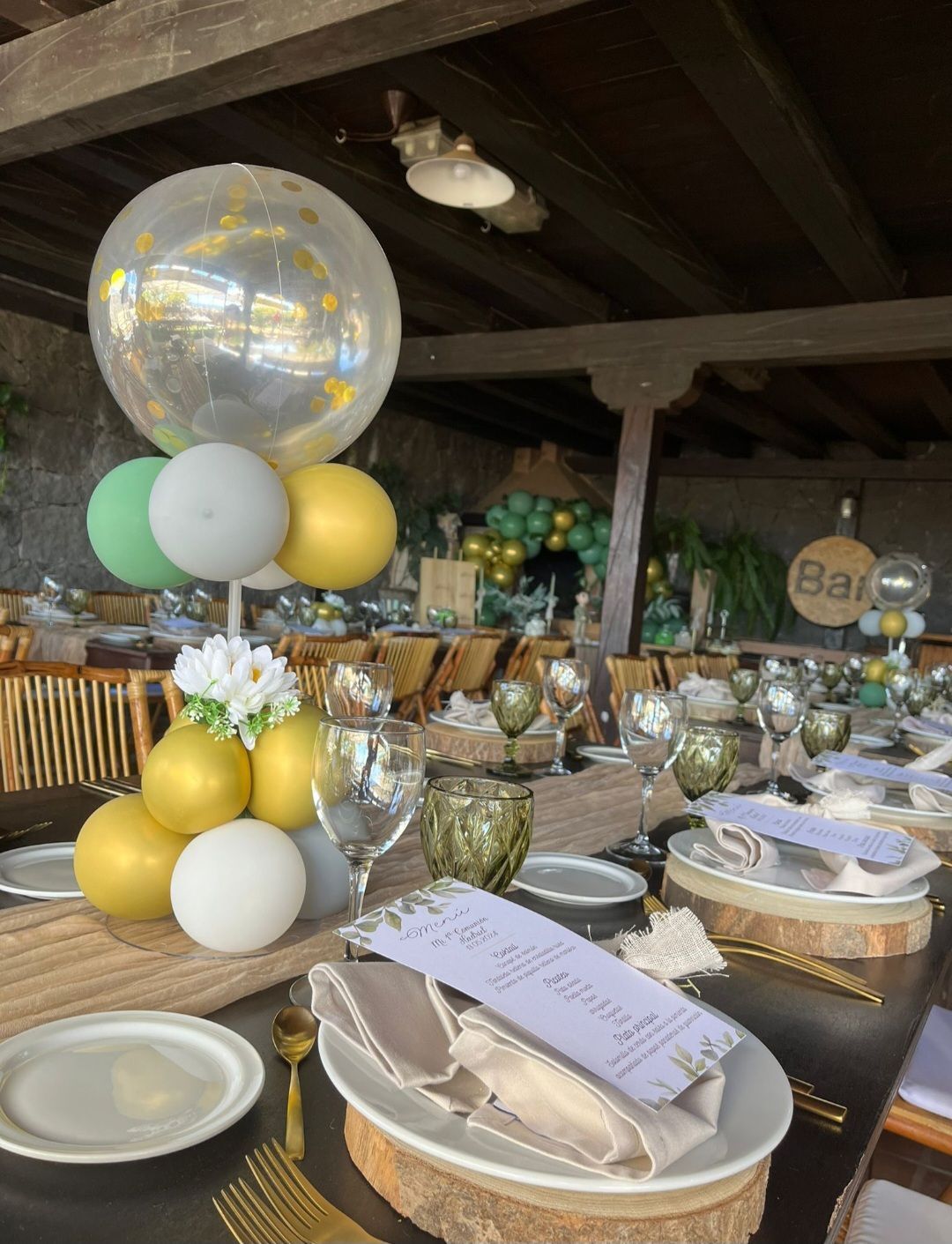 Una mesa preparada para una fiesta con platos, servilletas, vasos y globos.