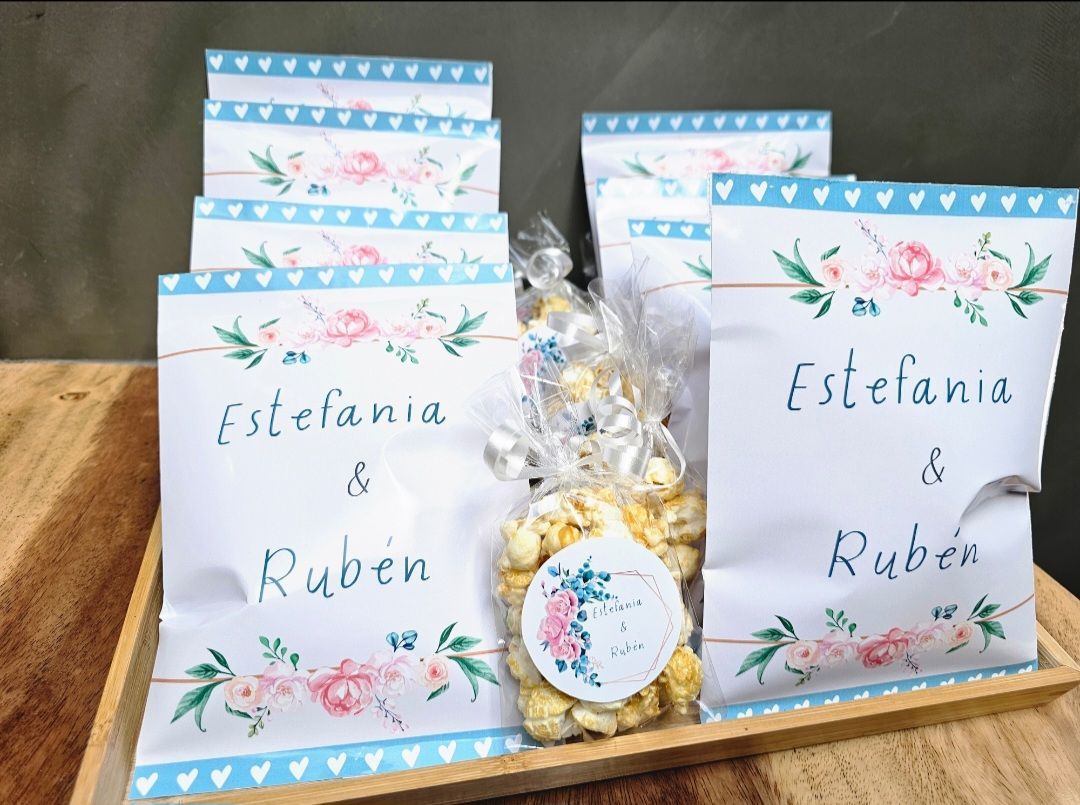 Una bandeja de madera con una bolsa de palomitas y un cartel que dice Estefanía y Rubén.