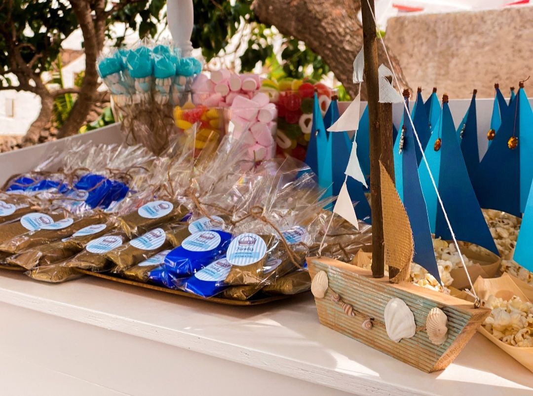 Una mesa con un barco y dulces encima.