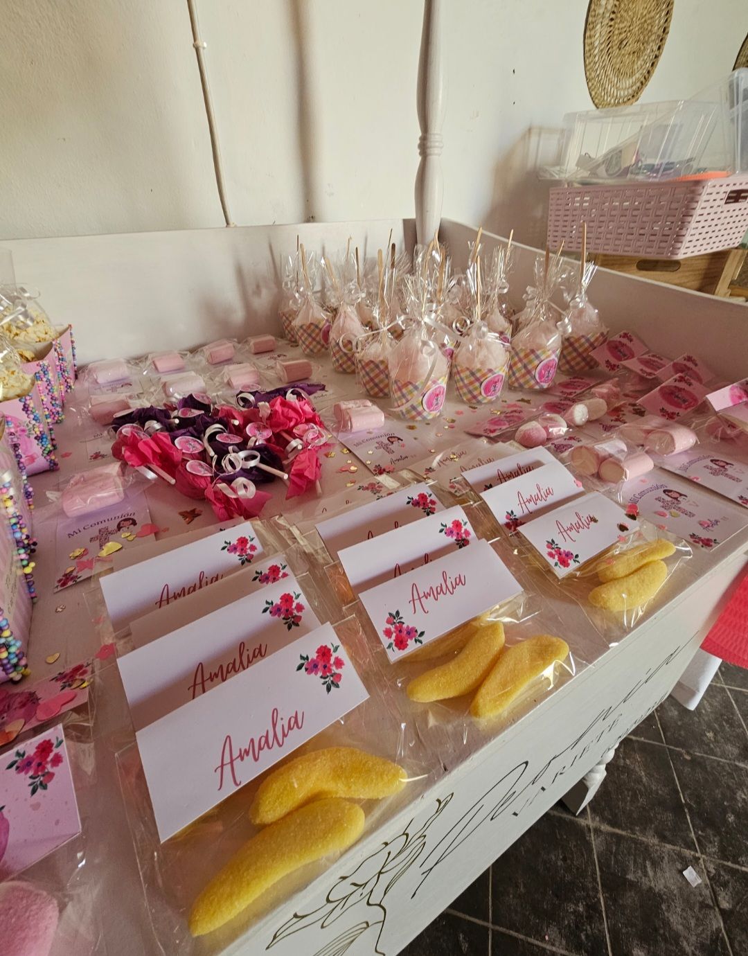 Una mesa llena de dulces y una etiqueta con el nombre Amelia.